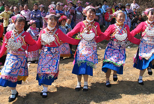 Minority girls dressed in colorful ethnic clothes in Anshun are singing and dancing happily.